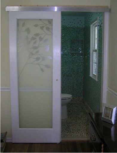 Claremont glass door hung with modern barn door style hardware.  Cool bathroom.